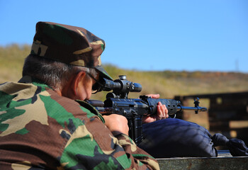 An unidentified man in uniform fires an SVD sniper rifle. 
