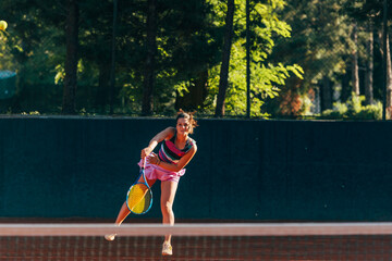 Professional equipped female tennis player serving the tennis ball on a sunny day