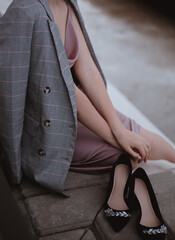 Woman sitting in a jacket in a dress black shoes fashion trend