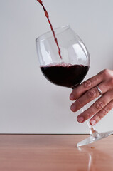 red wine is poured into a glass