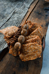 Quail egg satay and fried tempeh on wooden table. Yogyakarta typical angkringan food menu