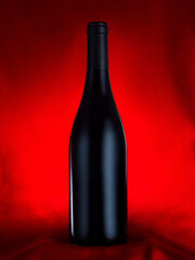 Una botella de vino sin etiqueta sobre fondo rojo