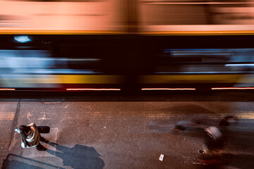 view from above at the people standing on the bus stop at night, blurred bus passing them, and...