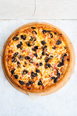 Pizza with mozzarella cheese, ham, mushrooms, chicken and sauce on gray background