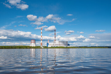 View from the river on Permskaya GRES, Dobryanka, Perm krai, Russia, Kama river blue sky with clouds, reflection in the water. - 410719396
