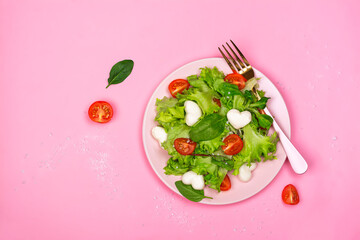 Fresh mx salad with tomatoes and heart shaped mozzarella cheese. Valentines day food. Copy space