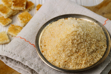 Bread crumbs or breadcrumbs in plate on wooden table