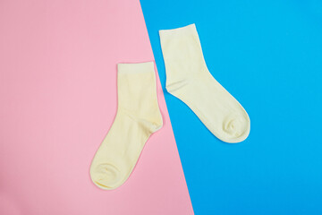 multicolored jersey socks on a pastel pink and blue background. view from above