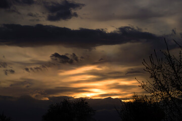 Sunset in the wild. A trip to Europe. Bright yellow sunspots among black clouds.