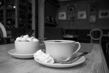 Vintage Cup Of Tea With Meringue and Sugar. Blurry Restaurant Background Black And White Image. Cafe Scene.