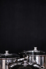 Set of grill pans on wooden table against black background, space for text