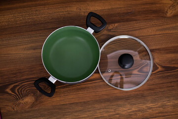 Set of grill pans on wooden table against black background, space for text