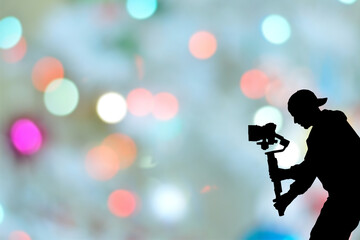Silhouette of videographer is filming with cinema gimbal video dslr, professional video, videographer in events. Cinema lens on gimbal. Medium shot. Film or cameraman school. Space for text