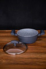 Set of grill pans on wooden table against black background, space for text