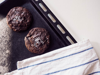 Still life of caramel-chocolate cookies on a baking tray.