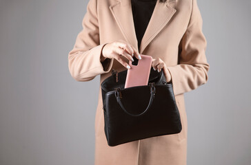 woman holding phone into bag