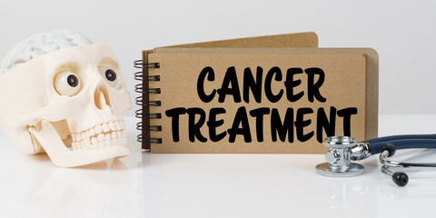 On the table lies a skull, a stethoscope and a notebook with the inscription - CANCER TREATMENT