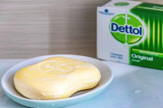 Glasgow, Scotland - April 16, 2020: Close-up on the antibacterial Dettol soap bar placed on a blue soap dish on a bathroom sink with the box with Dettol logo in the background. 