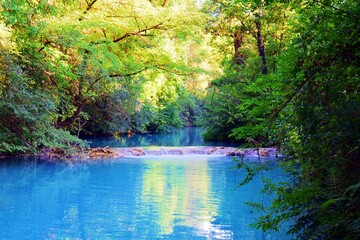 landscape of the Elsa river, known as the turquoise river, inside the river park in Siena in Tuscany, Italy. The blue color of the water is due to the thermal springs that feed it