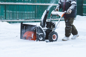 a man removes snow with a snow plow after a heavy snowfall near his house, close-up, blizzard, snow...