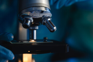 Close up of scientist hands working on microscope inside laboratory - Vaccine against coronavirus concept -Focus on optics