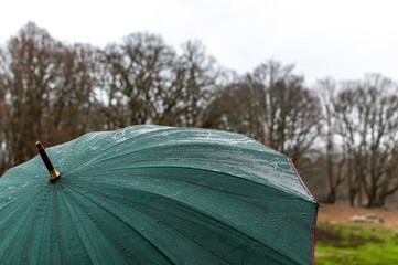 Dark green umbrella in rainy day
