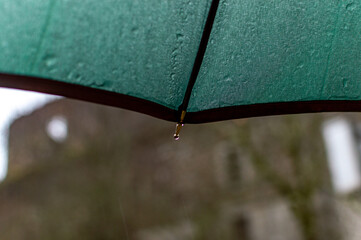Dark green umbrella in rainy day