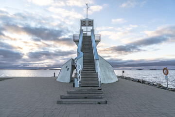Symmetric lighthouse in Nallikari, Oulu, Finland. Scenic evening skyline over Baltic sea with...