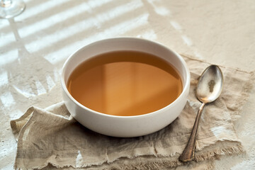 A bowl of beef bone broth on a white background