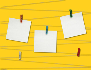 Three note sheets on clothespins on a yellow background