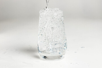 clean water is poured into a glass cup.
