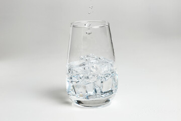 clean water is poured into a glass cup. ice in a glass.