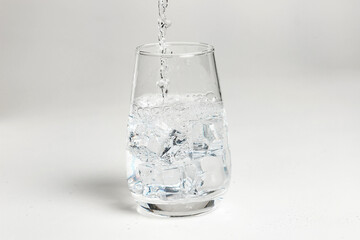 clean water is poured into a glass cup.