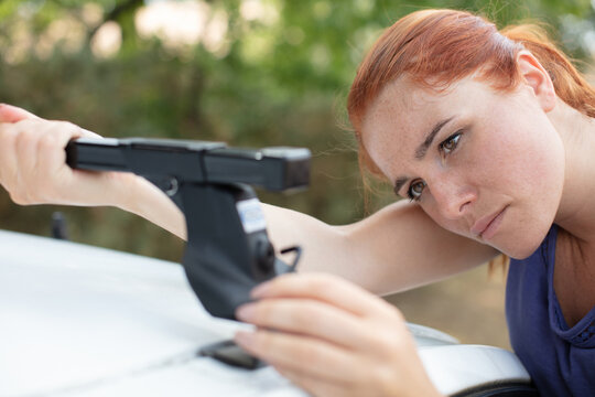 Woman Fixing Roof Bars On Top Of Her Car