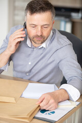 Naklejka premium man talking on landline phone - operators in the office
