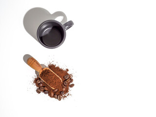 Ground coffee with beans in wooden spoon.