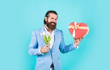 Time to shop. love gift for romantic date. bearded man in elegant jacket hold flowers. wedding day. happy valentines day. bride groom with bouquet and box. hipster man hold tulip flowers