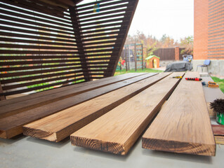 Brown color stain painting on wooden table or fence or wall, or flour, use for home decorated. House renovation. Half - painted surface. Hand holding brush. Background with copy space.