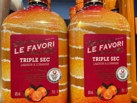 Viersen, Germany - February 3. 2021: View on bottles french le favori triple sec orange fruit liqueurs in shelf of german supermarket