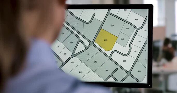 woman working with digital cadastral map land register database on computer in office. building plot for sale