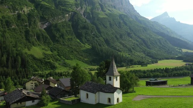 Medels im Rheinwald, Swiss Alps cliffs, green meadows and a village
