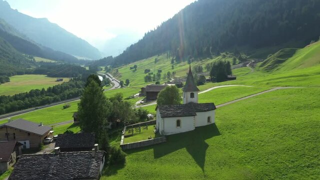 Medels im Rheinwald, Swiss Alps cliffs, green meadows and a village