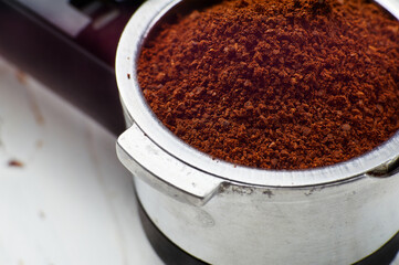 Coffee filter holder full of fresh ground coffee. Coffee portafilter. Macro, close-up