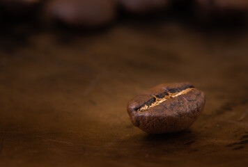 Single coffee bean after roasting on brown dark metal bar table
