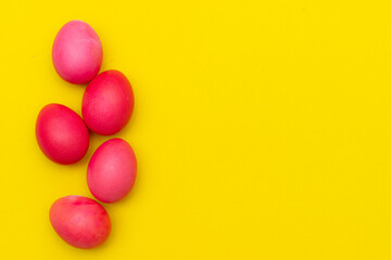 Obraz premium Painted eggs on a yellow background. Chicken eggs on a yellow background. Chicken eggs are colored. Easter. Orthodox holiday. An article about Easter. Article about eggs benefits and harms. Copy space