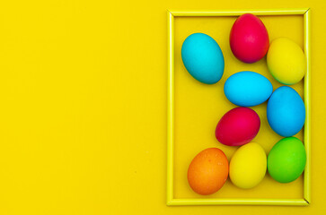Painted eggs on a yellow background. Chicken eggs on a yellow background in a frame. Space for the text. Chicken eggs are colored. Easter. Orthodox holiday. An article about Easter. Article about eggs
