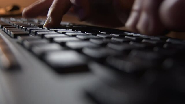 Fingers writing in a black computer keyboard