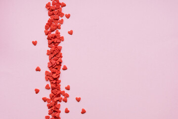 Abstract pink background with red sugar hearts. Valentine's day background.