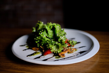 Delicious autumn mushroom salad with grilled mushrooms, tomato, fresh lettuce and rocket served in a bowl with toasted baguette