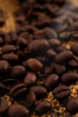 A close up photo of coffee beans with to beans bean lit by a beam of light and is the main focus point